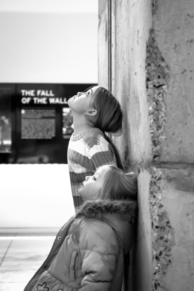 Two girls stand next to a wall possibly the Berlin Wall at the Newseum in Washington DC NotSoSAHM