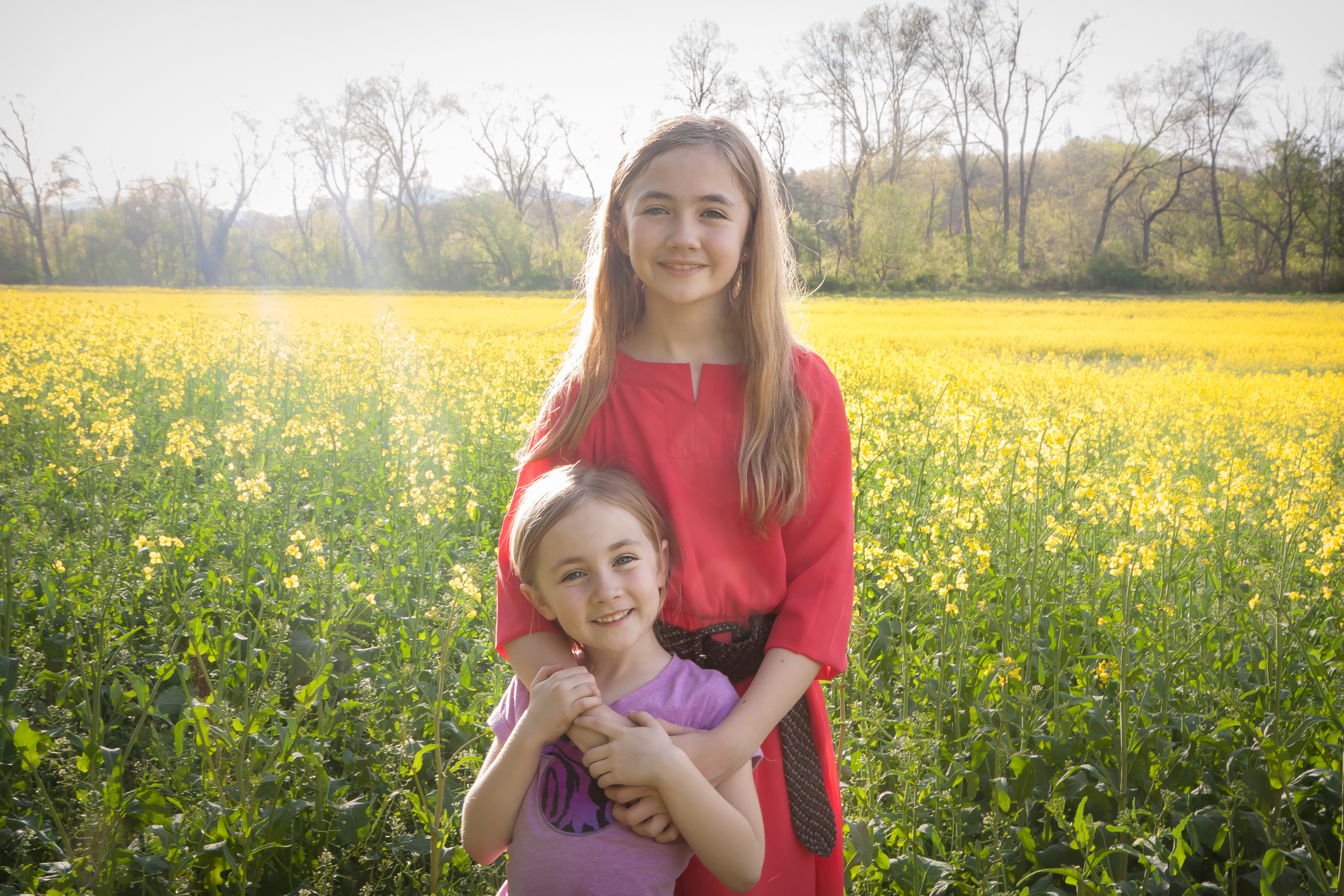 Two girls stand in a field of yellow flowers near the Biltmore in Asheville, NC NotSoSAHM