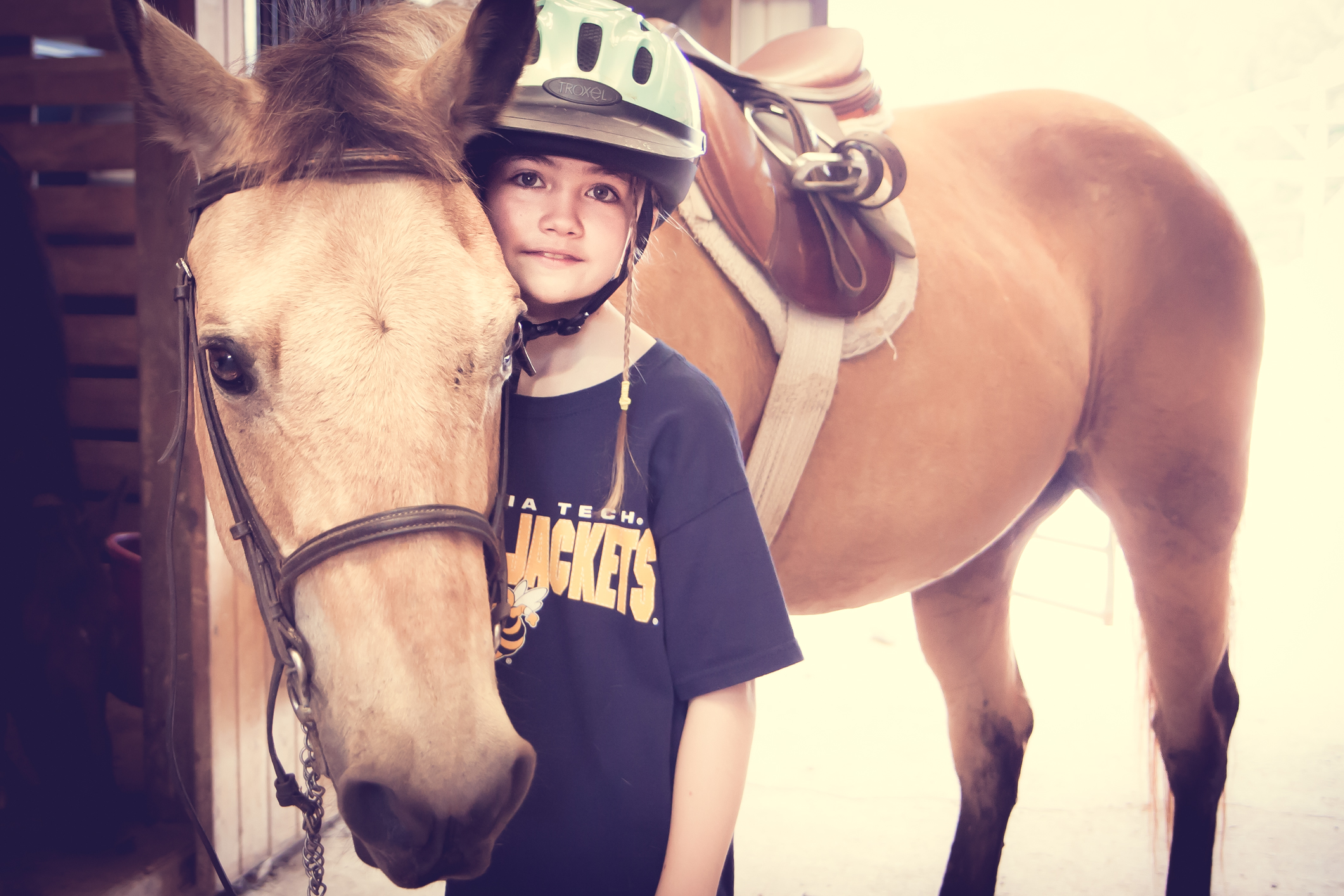 A girl stands with a horse in a barn NotSoSAHM