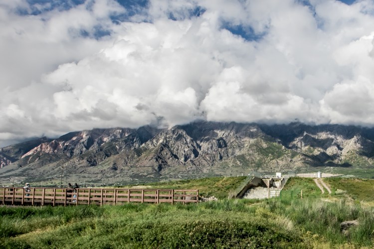 Clouds cover the mountains north of Salt Lake City, Utah, while several men stand on a bridge in the foreground NotSoSAHM