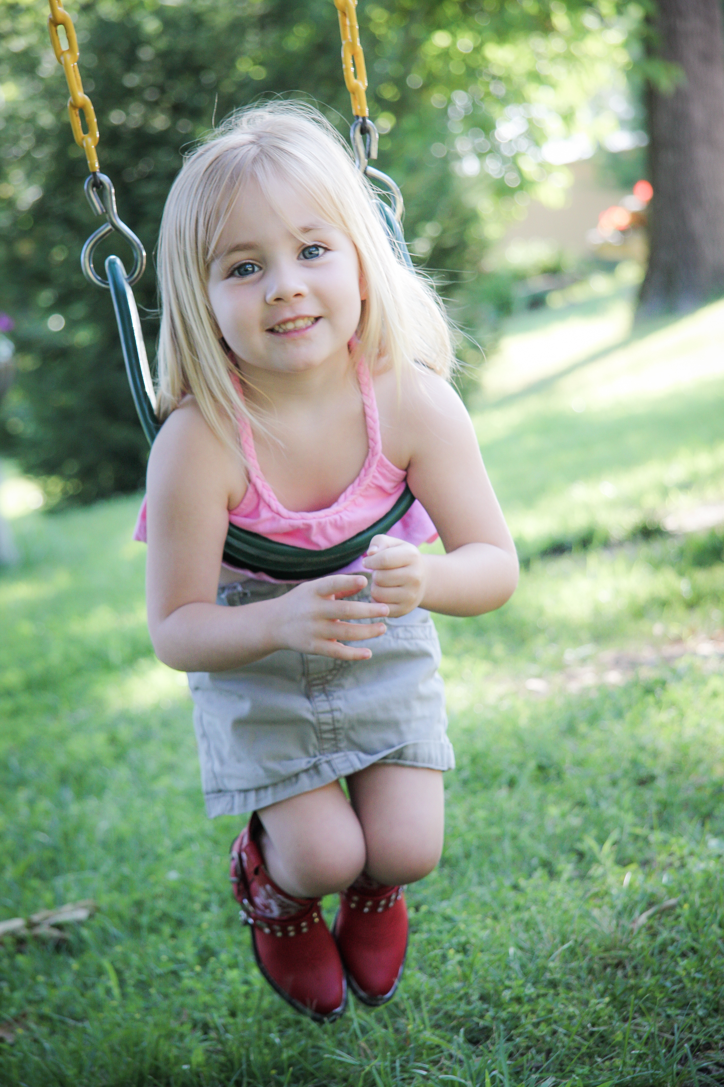 A girl in red boots plays in a swing Not So SAHM