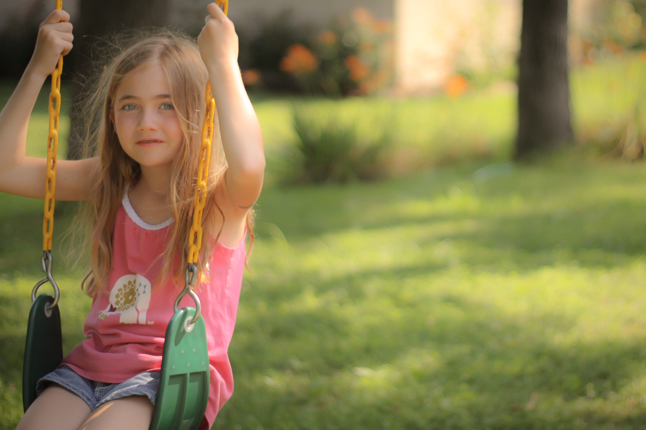 A girl sits in a swing under a tree in summer Not So SAHM