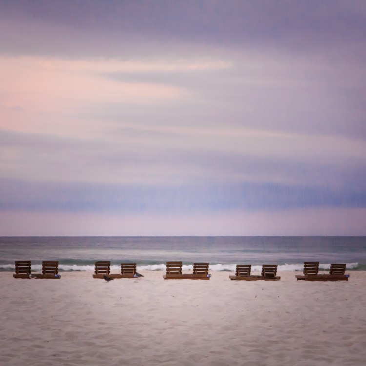 Pairs of wooden beach chairs line a Pensacola Beach Not So SAHM