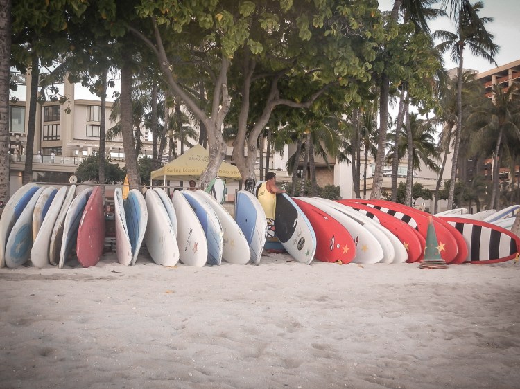 A man sets up surf boards for rent on Waikiki Beach on Oahu, Hawaii Not So SAHM