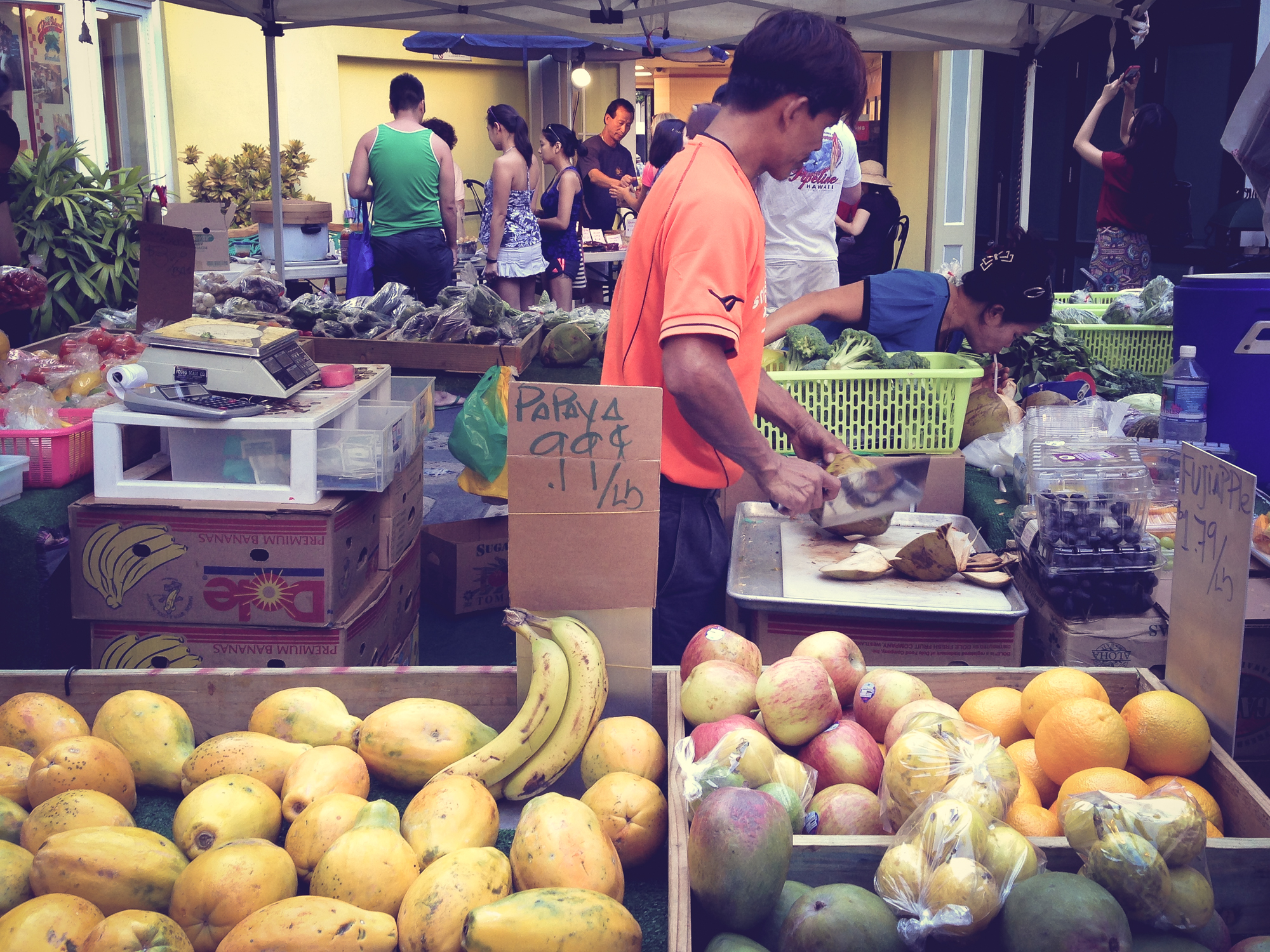 A seller chops up fresh coconut at a fruit stand in Waikiki Hawaii Not So SAHM