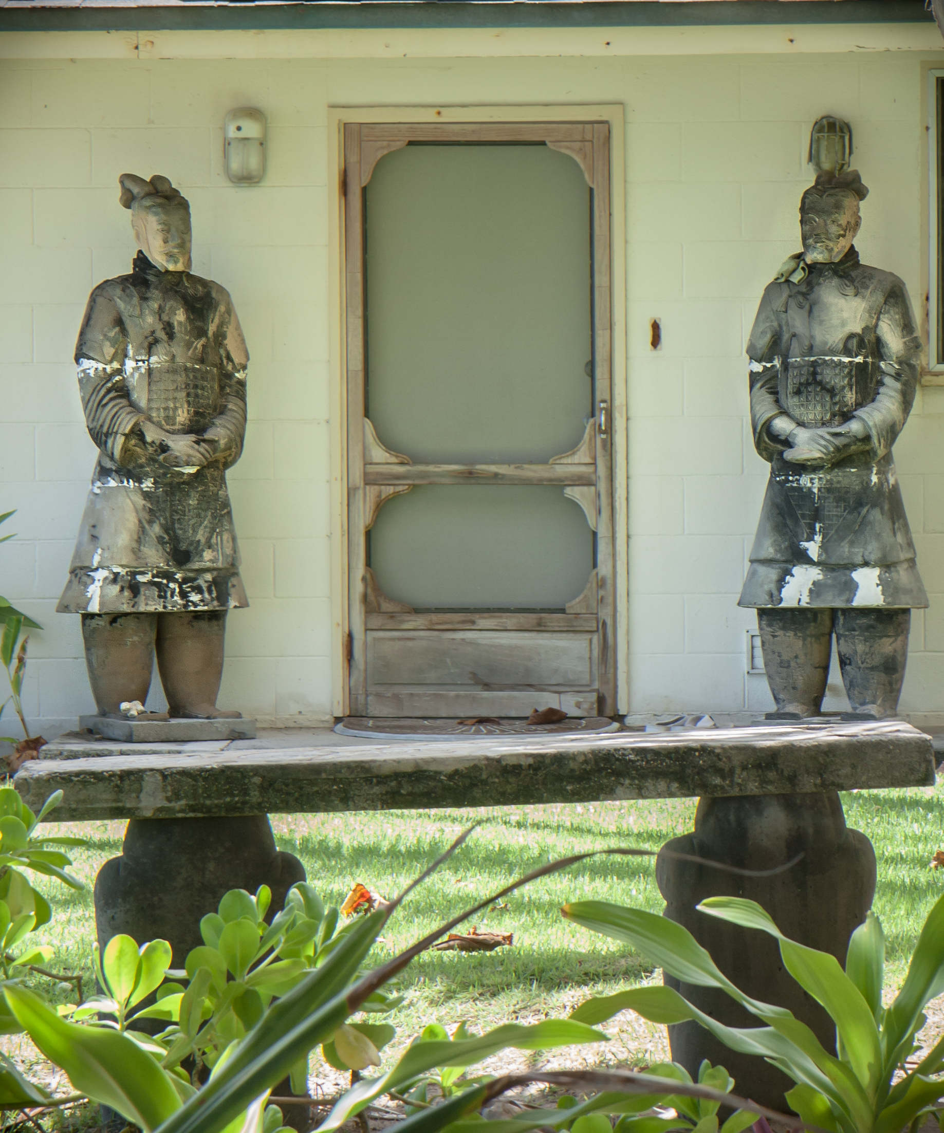 Two life-size asian statues stand on either side of a front door on a beach house on Oahu Not So SAHM
