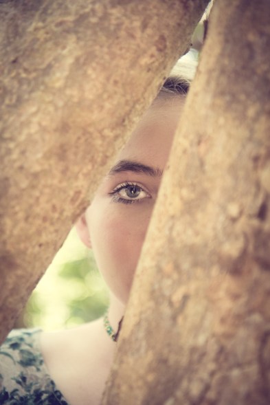 Girl peeks through trees and all you can see is one eye. Not So SAHM