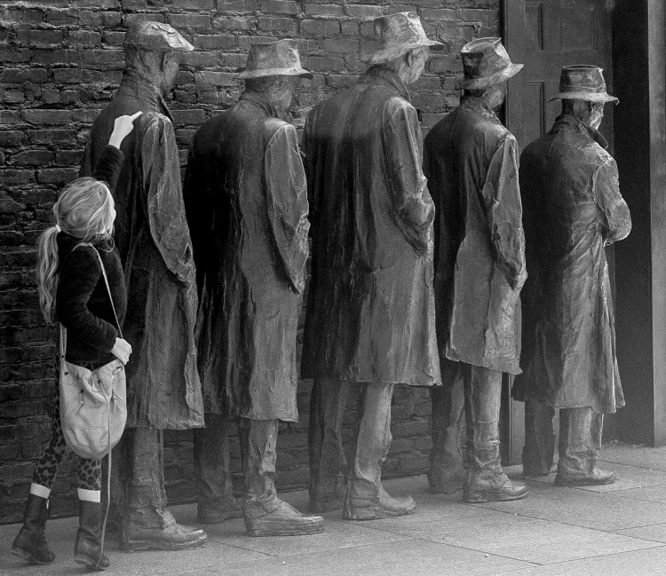 Girl stands in the back of statues waiting in a soup kitchen line at the FDR Memorial in Washington DC. Not So SAHM